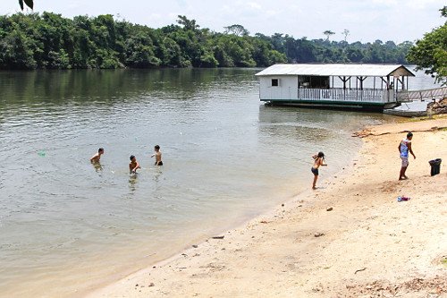 Bar Flutuante do Mané em Capitólio, localizado sobre as águas, com visitantes desfrutando do local durante o passeio de lancha.