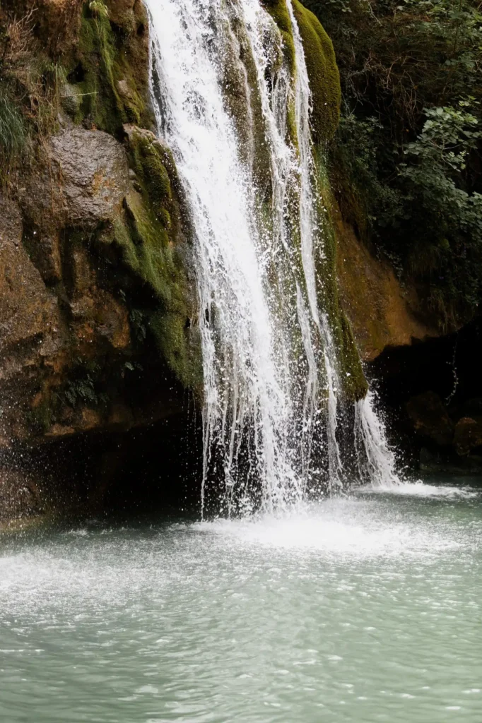 Cascatinha em Capitólio, com águas cristalinas descendo por uma cachoeira cercada por paredões rochosos.