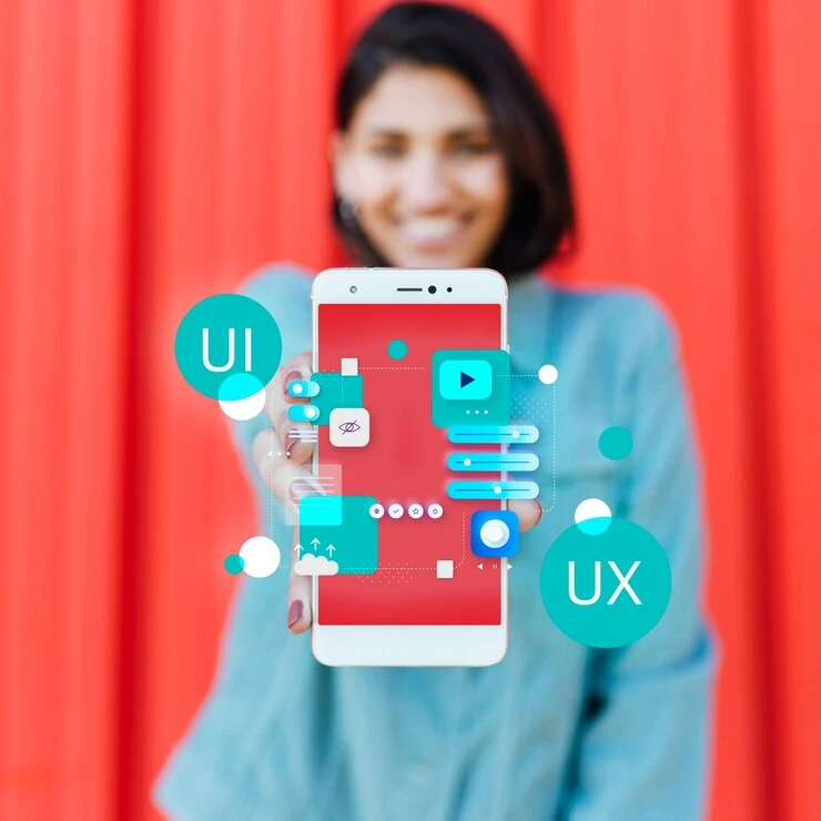 Imagem de uma pessoa segurando um smartphone que exibe ícones de UI e UX em um fundo vermelho. A imagem representa a importância do SEO Mobile para otimização de sites e aplicativos.