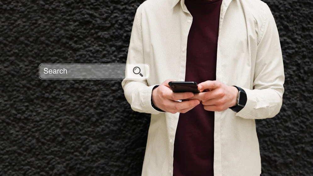 Imagem que ilustra o impacto do voice search no SEO, mostrando um homem usando um smartphone em busca de informações.