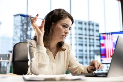 Mulher de negócio analisando documentos financeiros na mesa com foco na gestão de capital de giro e os 5 erros que podem impactar o início de 2026.